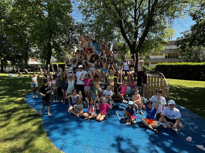 Die Kindersommer-Kinder haben sich bei einem Kletterfisch versammelt und für ein Foto mit dem Bürgermeister Aufstellung genommen.