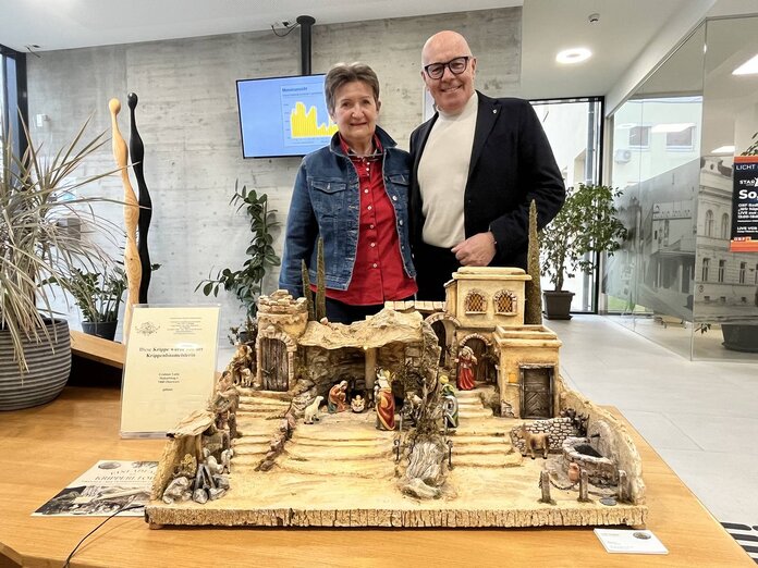 Lotte Grabner und Bürgermeister Georg Rosner stehen nebeneinander, davor ist die orientalische Krippe zu sehen.