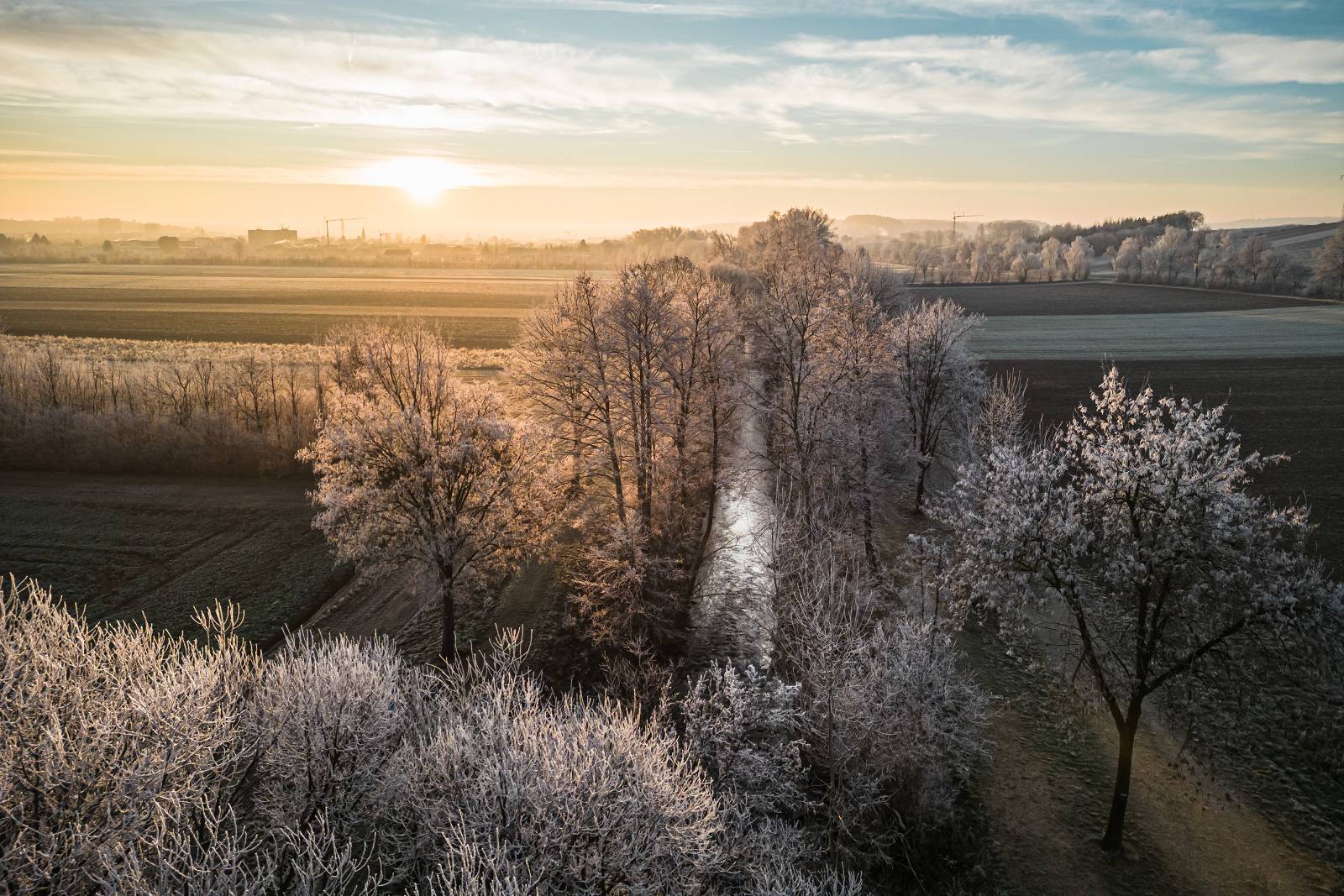 Drohnenaufnahme mit Blick auf die Pinka und die Bäume entlang. Es herrscht Winterstimmung